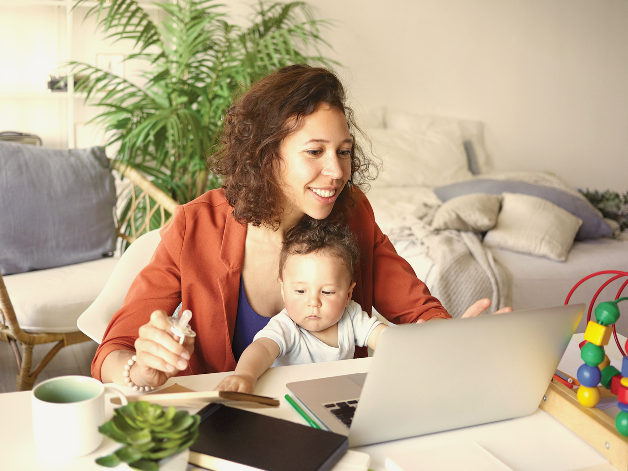 woman working online with baby on her lap