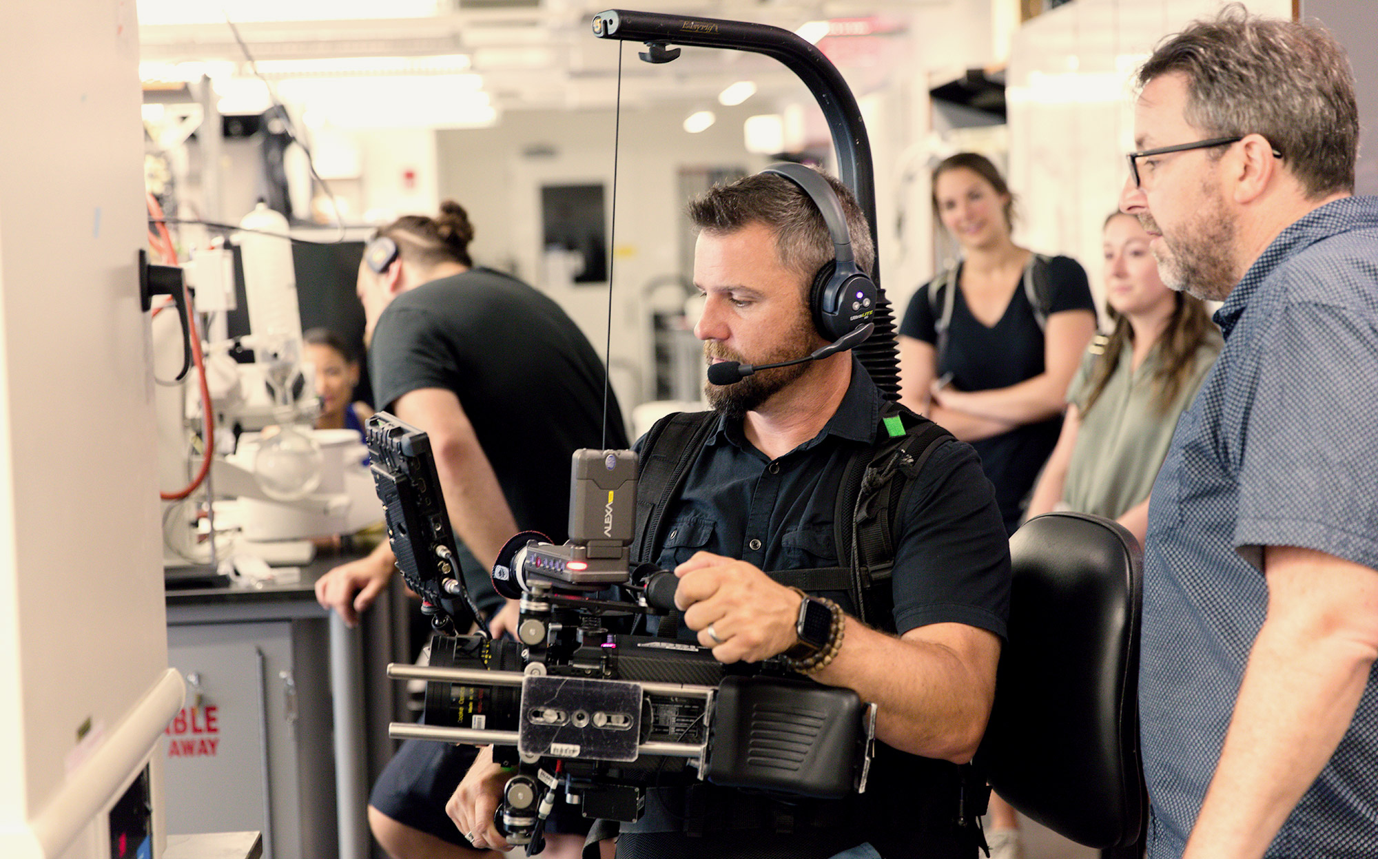 student learning about video camera from faculty