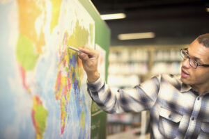 man standing in front of map of the world