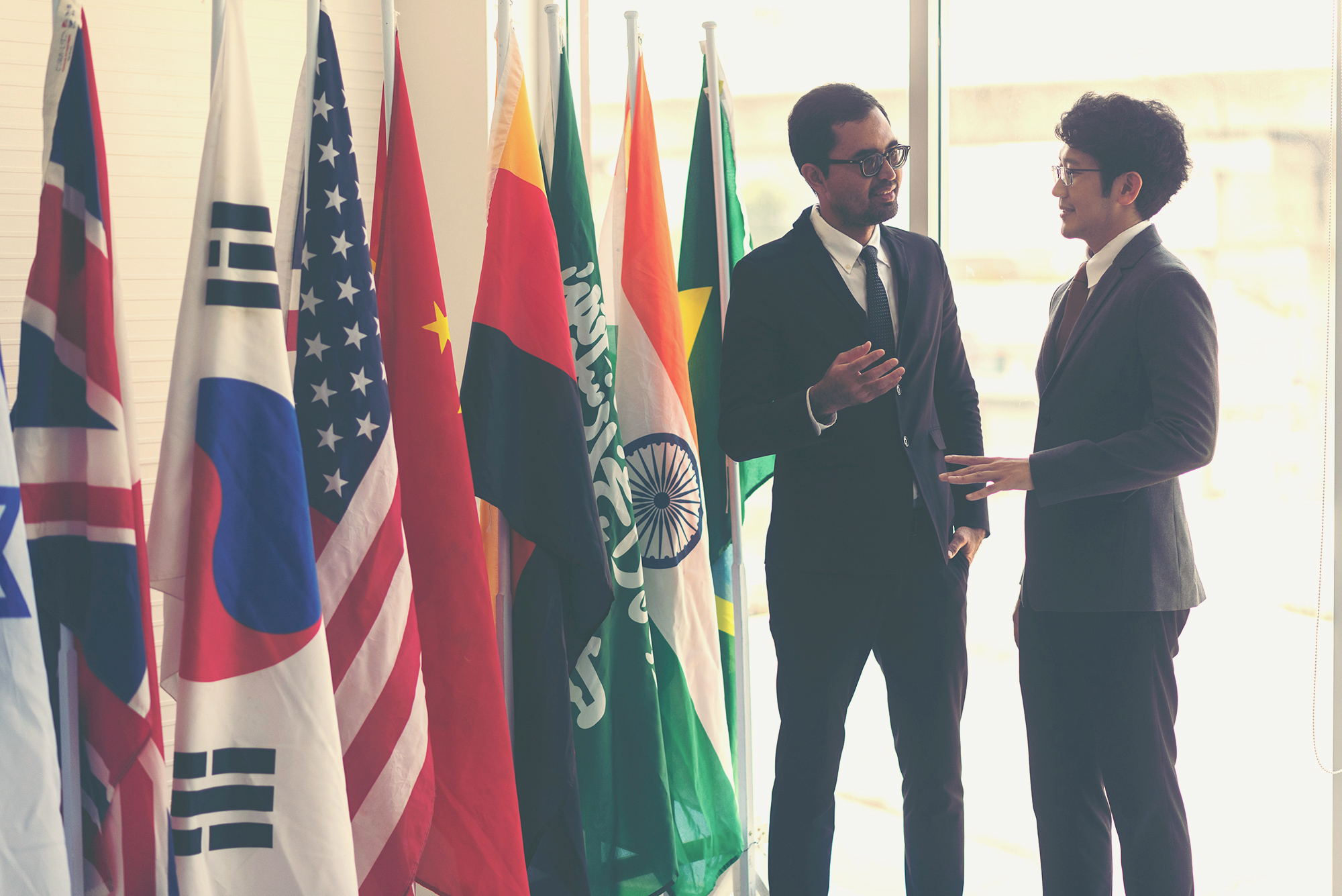 two people having conversation in front of international flags