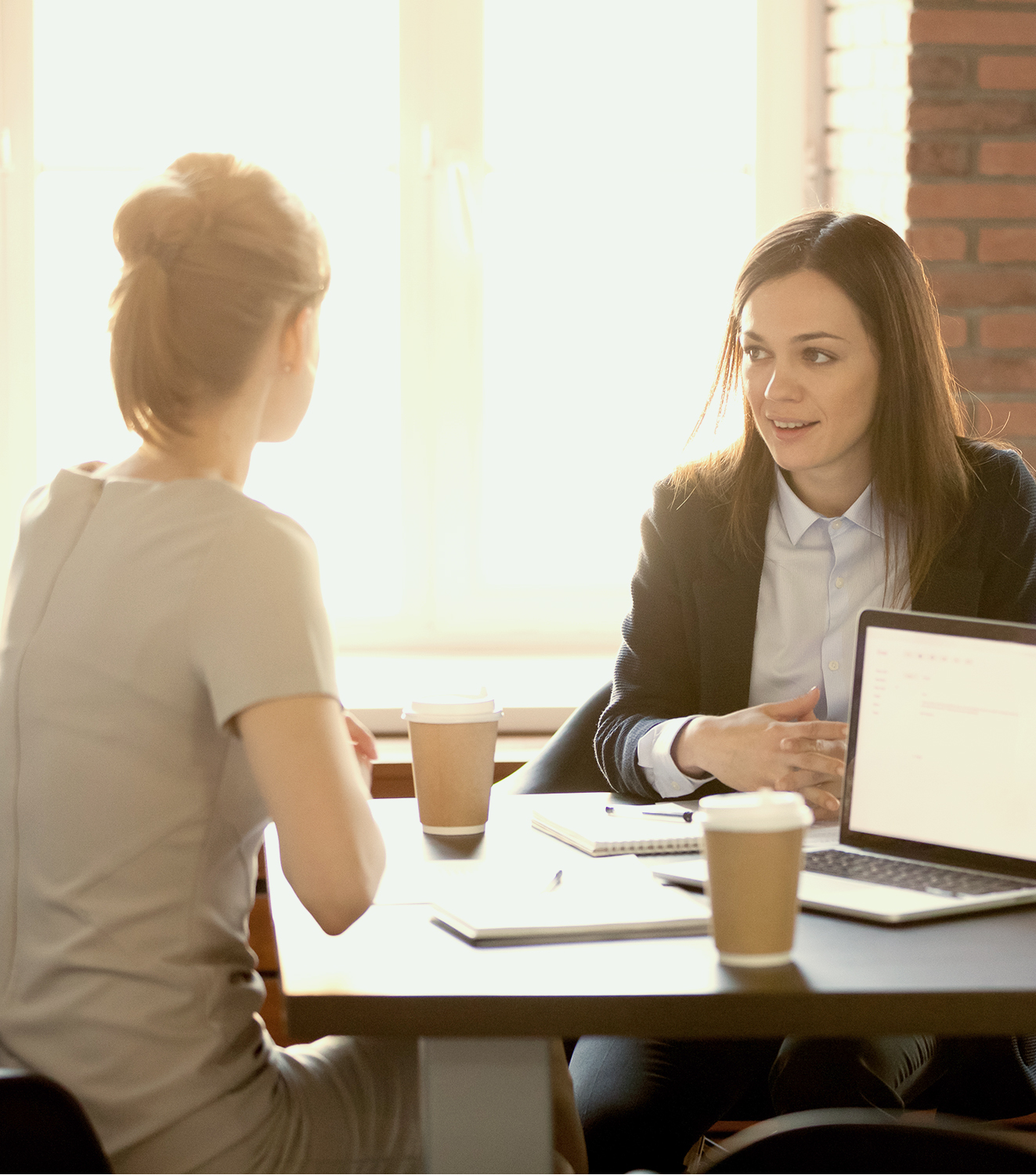 two women sitting at table in conversation