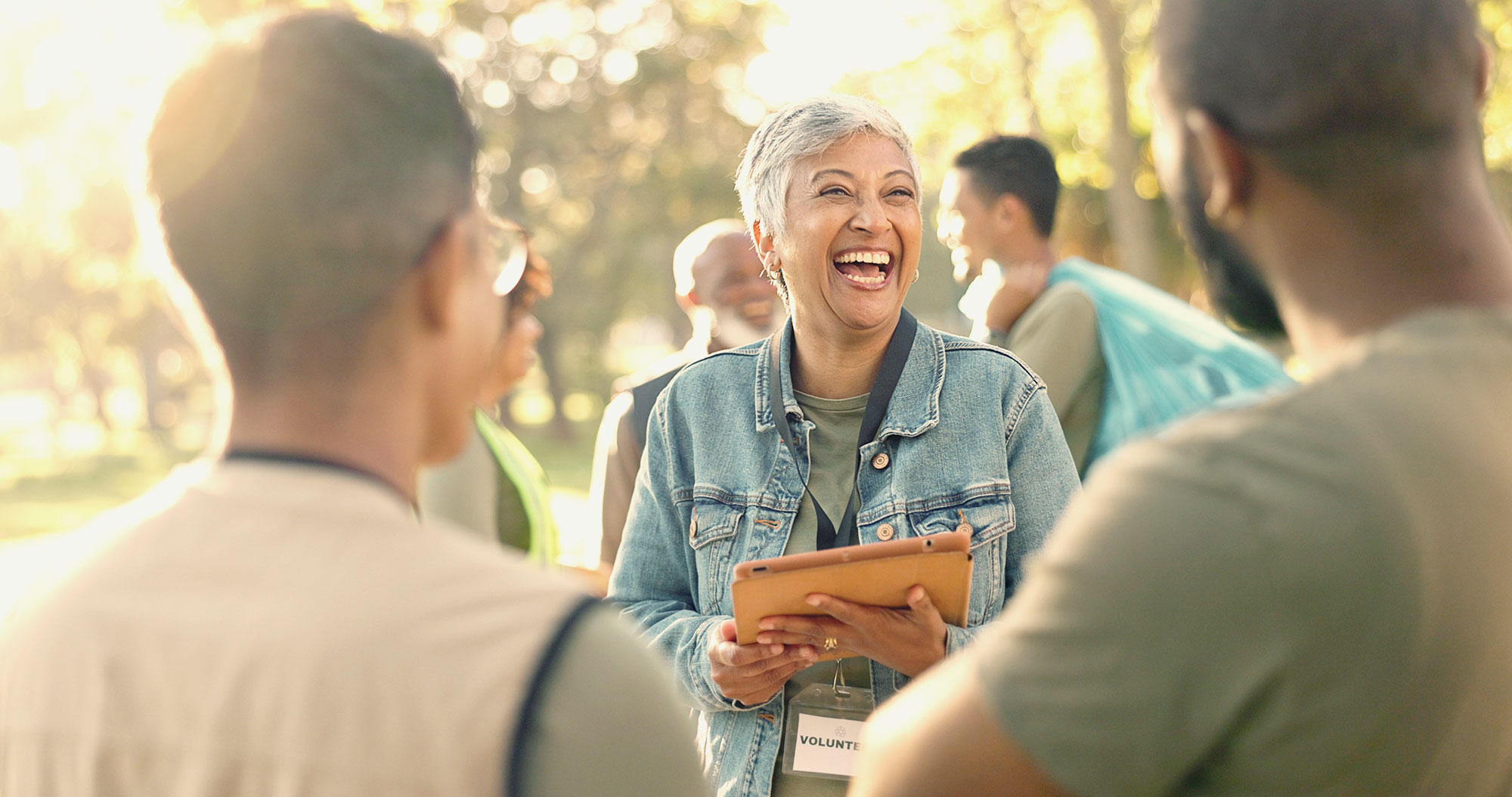 Smiling woman in park with employees.
