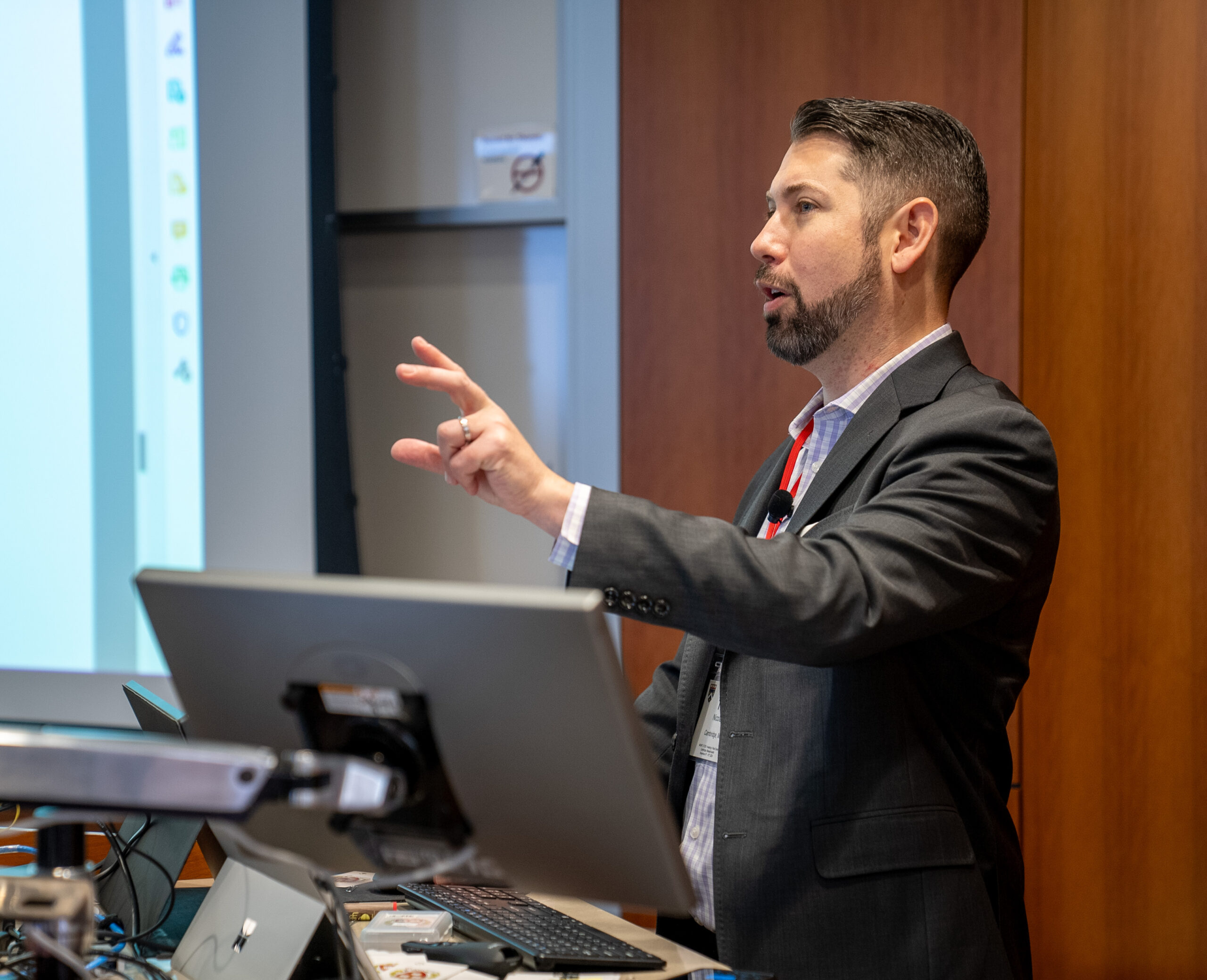 Instructor Teo Nicolais stands behind a desk while speaking to a class of HES students.