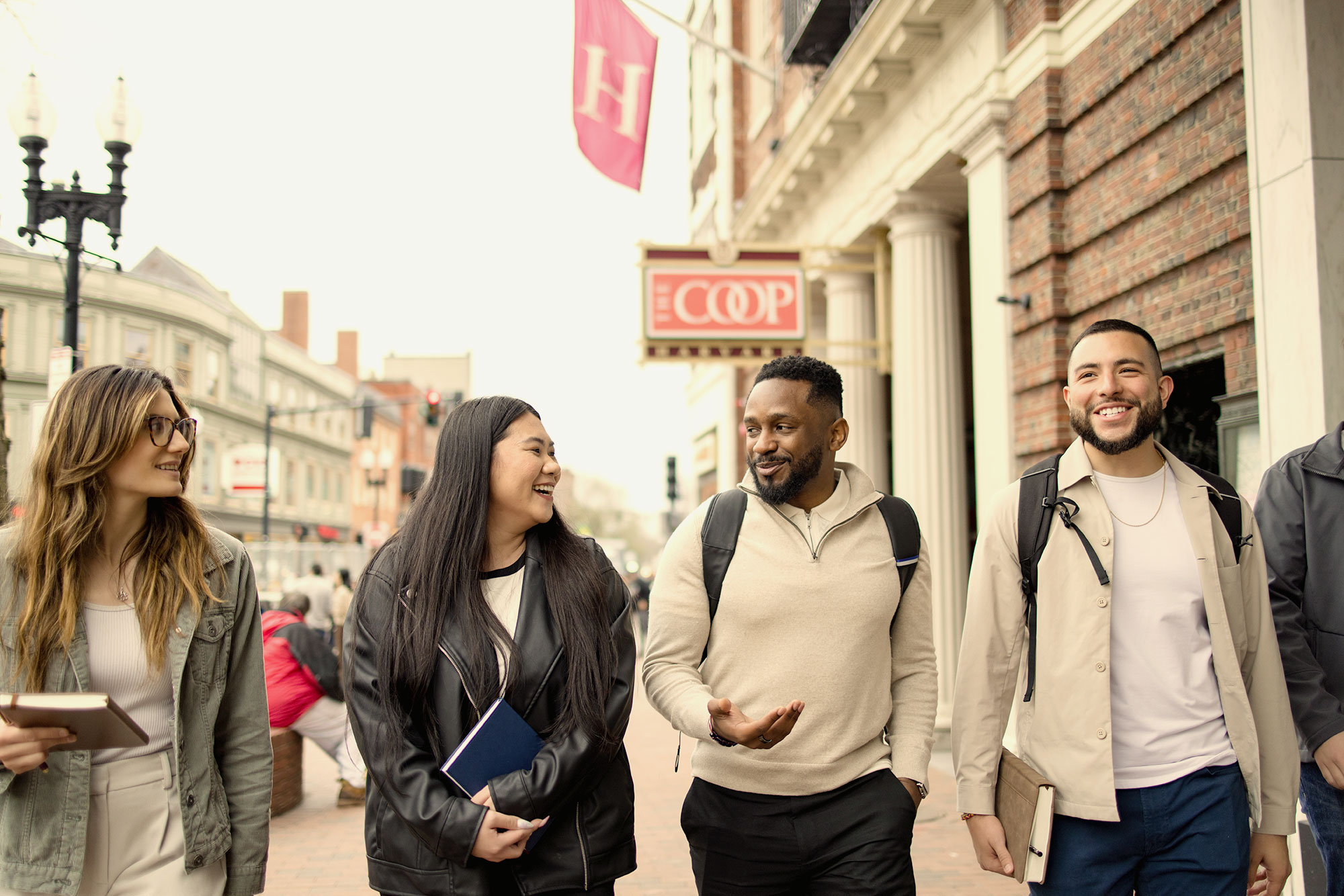 A group of Harvard Extension students walk past the Harvard Coop.