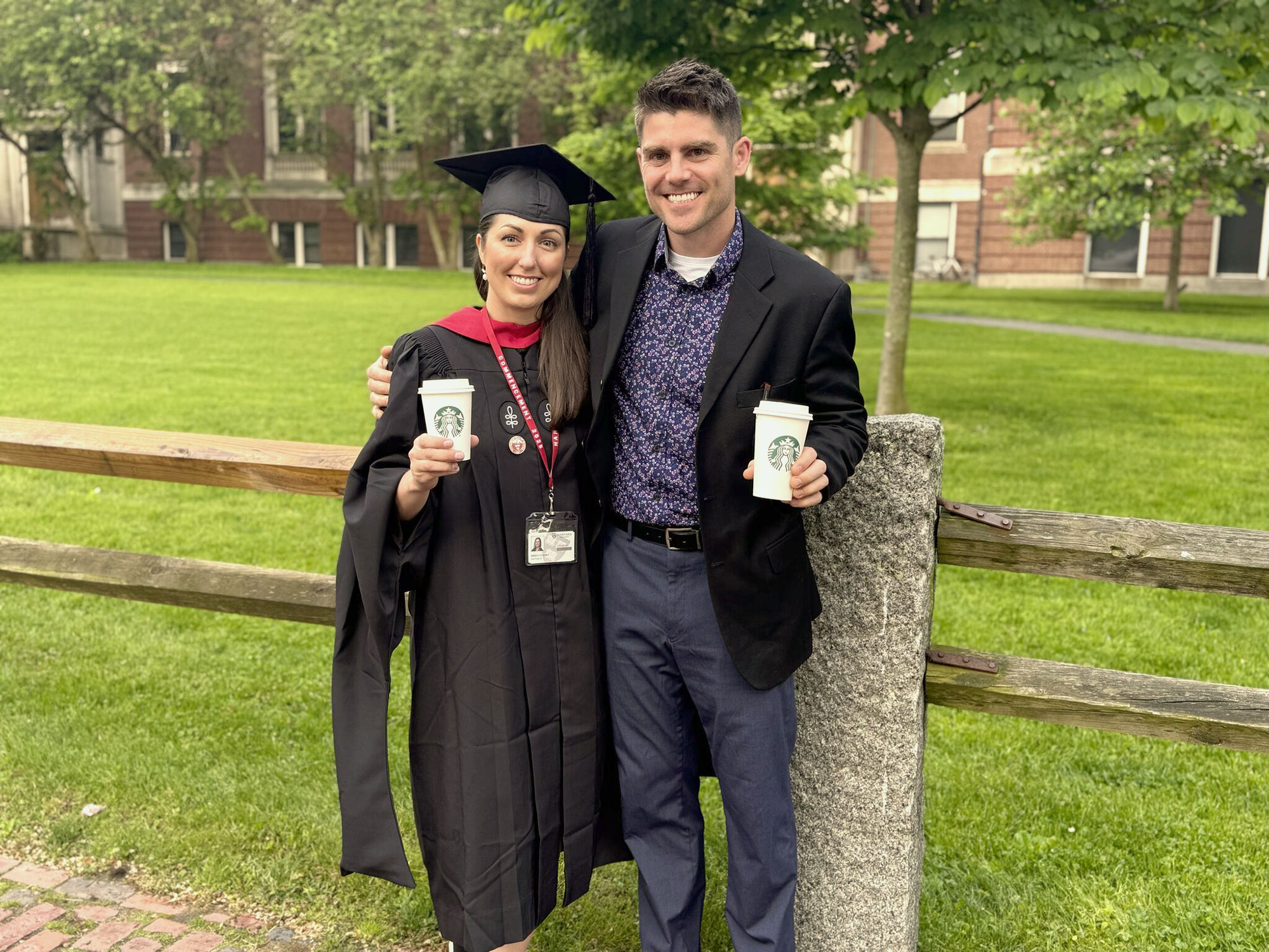 Becca and husband James at ALM graduation holding Starbucks cups.