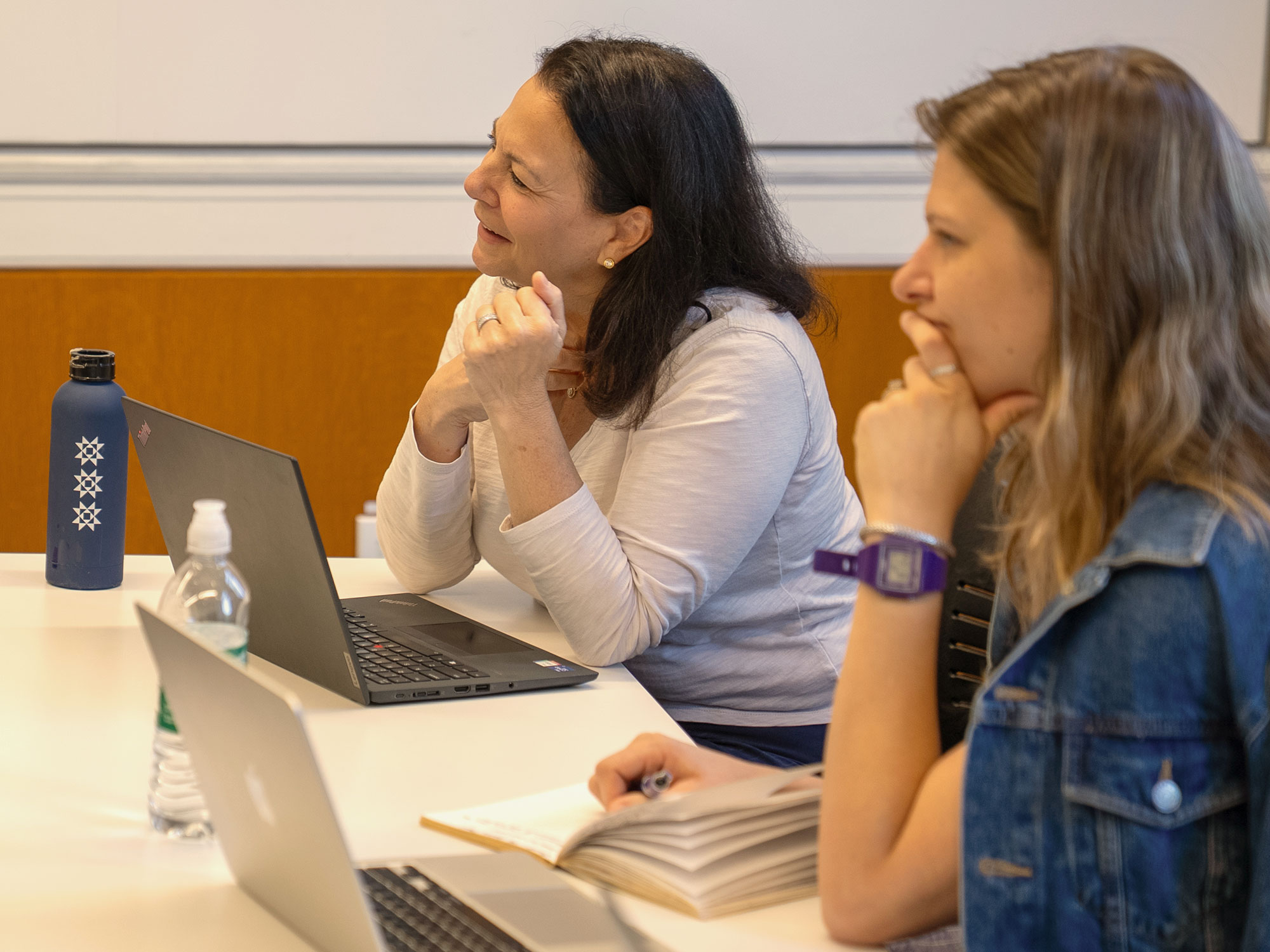 Two Harvard Extension students listen during an on-campus class.