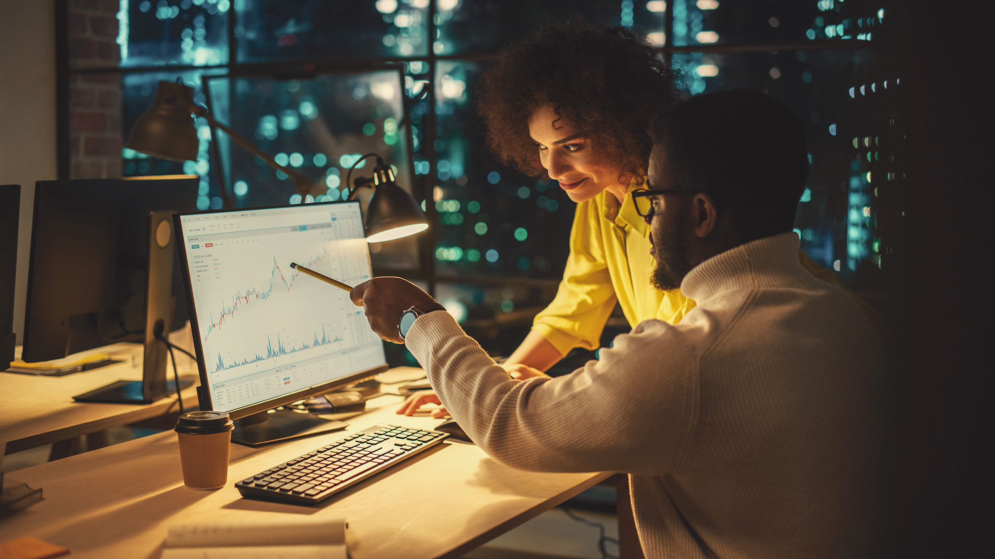 Two people looking at data on a computer.