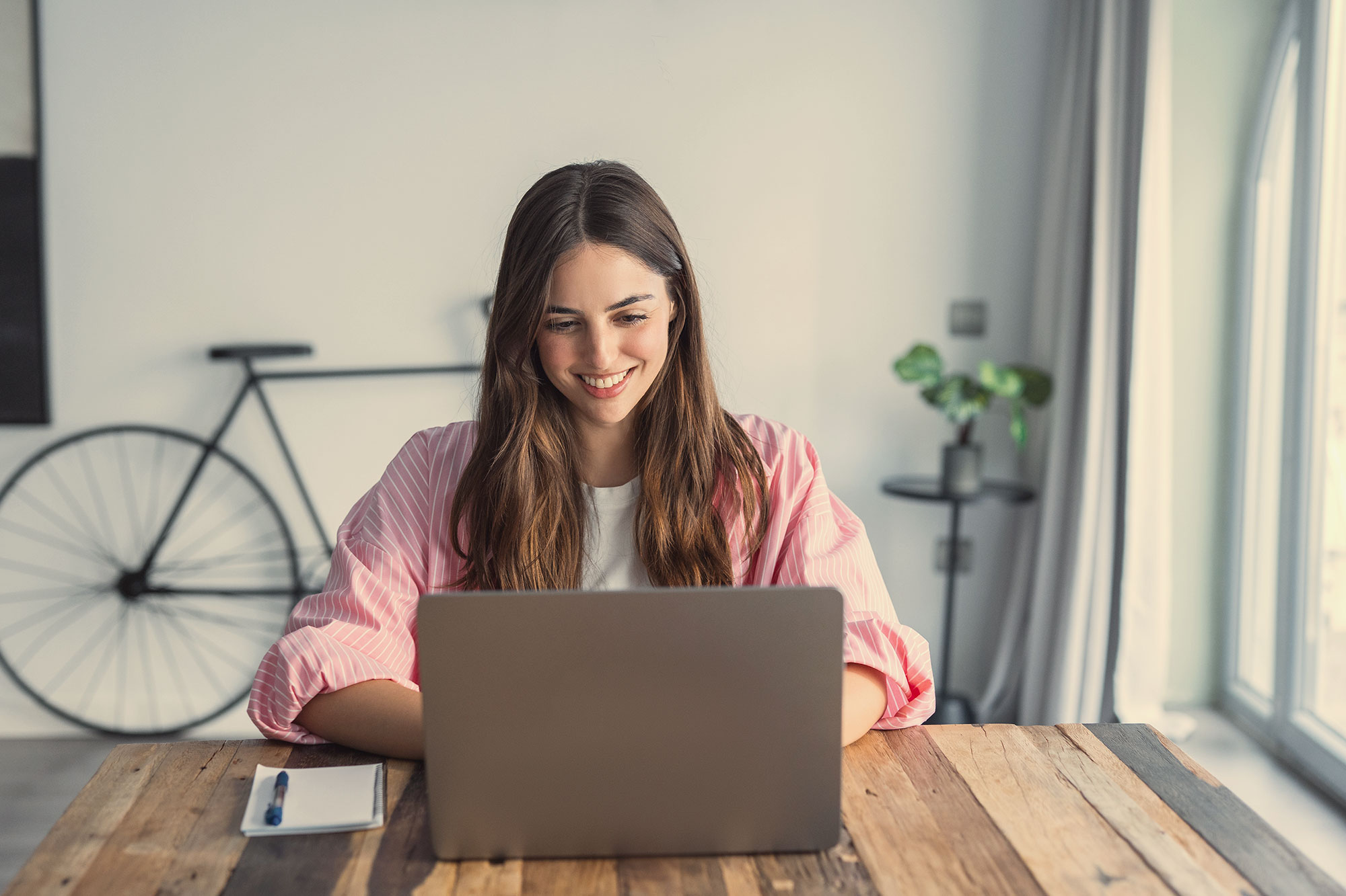 A woman working at a laptop.