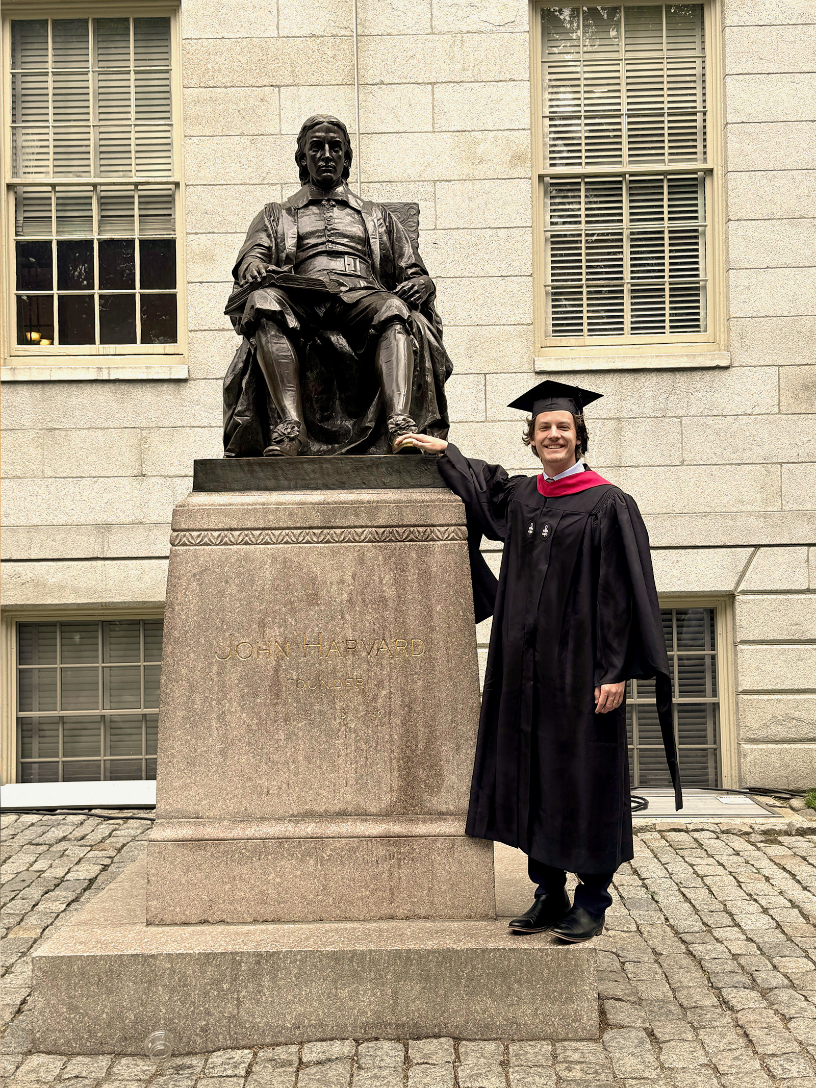 Cole Tibbs touching John Harvard statue.